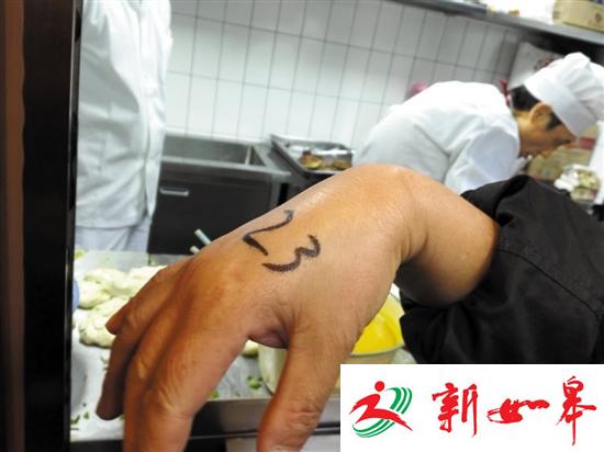 工作人员将号写在食客手上