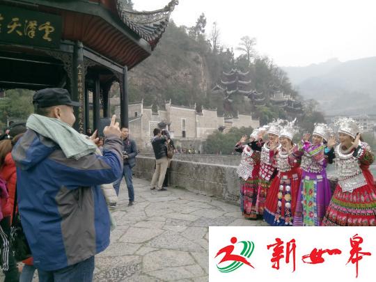 游客穿上苗族服饰在始建于明朝的祝圣桥上合影　周燕玲　摄