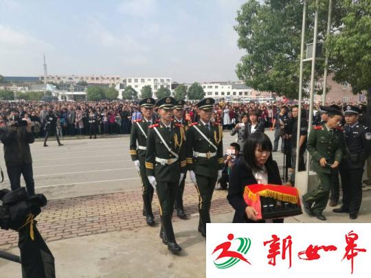 图为王锋妻子手捧王锋骨灰。 董飞 摄