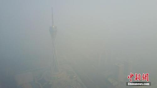 12月18日，河南郑州仍是雾霾围城，图为隐身于雾霾之中的河南广播电视发射塔。王中举 摄