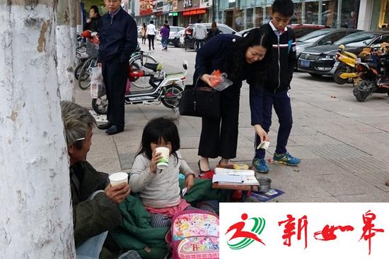 小女孩随父亲街头乞讨寒风中裹棉被写作业