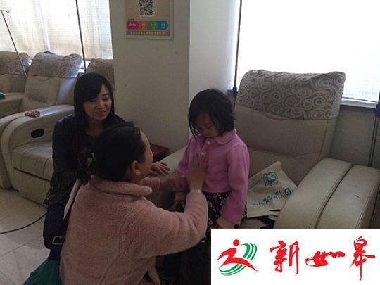 图为出发前往福利院之前,一位爱心人士为王金丽换上新衣服。 王秋兰 摄