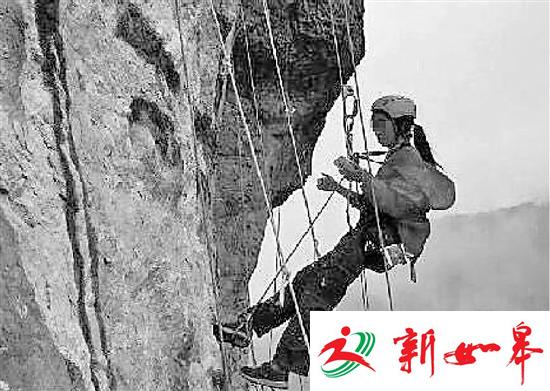 玲玲吊着绳索在岩壁上作画（网友提供）。