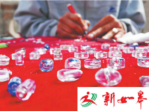 孙传富将刻好的大米装在琉璃饰品里，看上去精致漂亮。